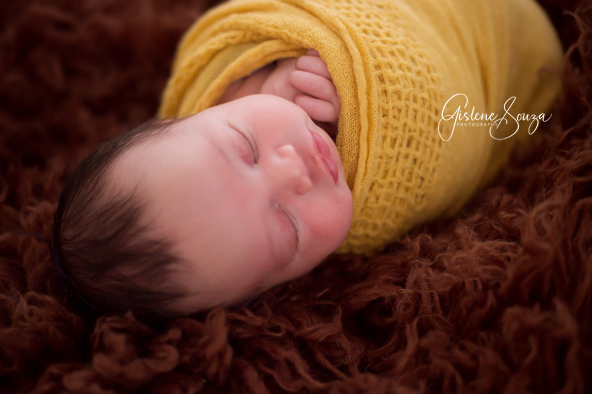 Ensaio fotográfico newbor  em Belo Horizonte, Uso das cores amarelo e marrom. Belê enrolado no wrap.