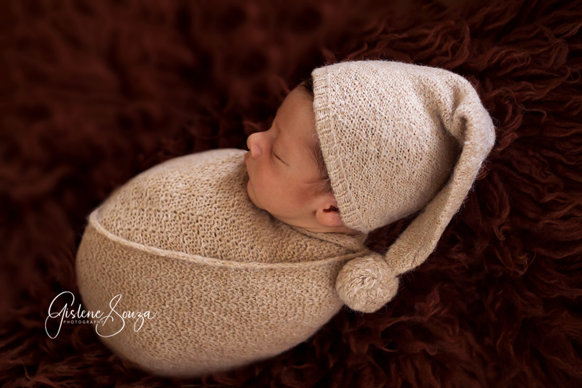 Fotografia de recém nascido em Pará de Minas, em estúdio. Pose no pelo sobre o puff.