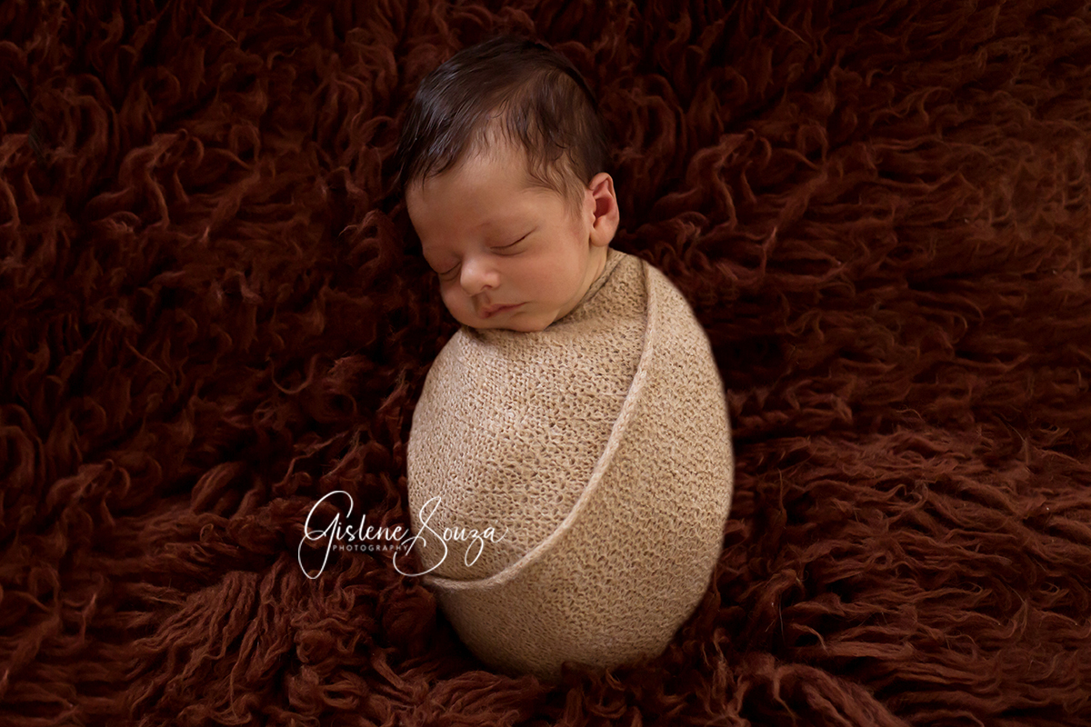 Fotografia de newborn em Pará de Minas. Menino, pose no puff enrolado no Wrap.