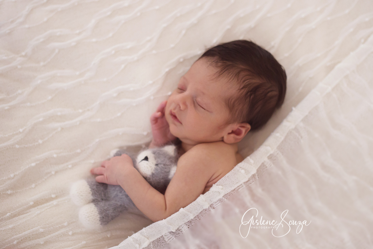 Fotografia de recém nascido em Pará de Minas. Pose no puff com gatinho e de ladinho.