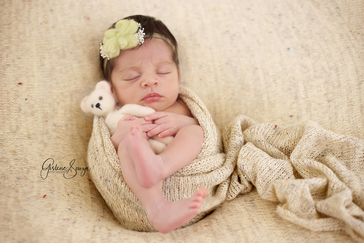 Newborn em Belo Horizonte. Ensaio de menina no puff, e enrolada no wrap com ursinho. Composição monocromática nos tons de bege.