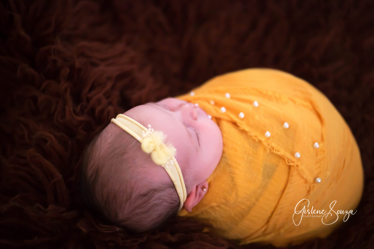 Fotografia de newborn da Ana Clara de 13 dias em Pará de Minas. Pose enrolado no wrap no Flokati.