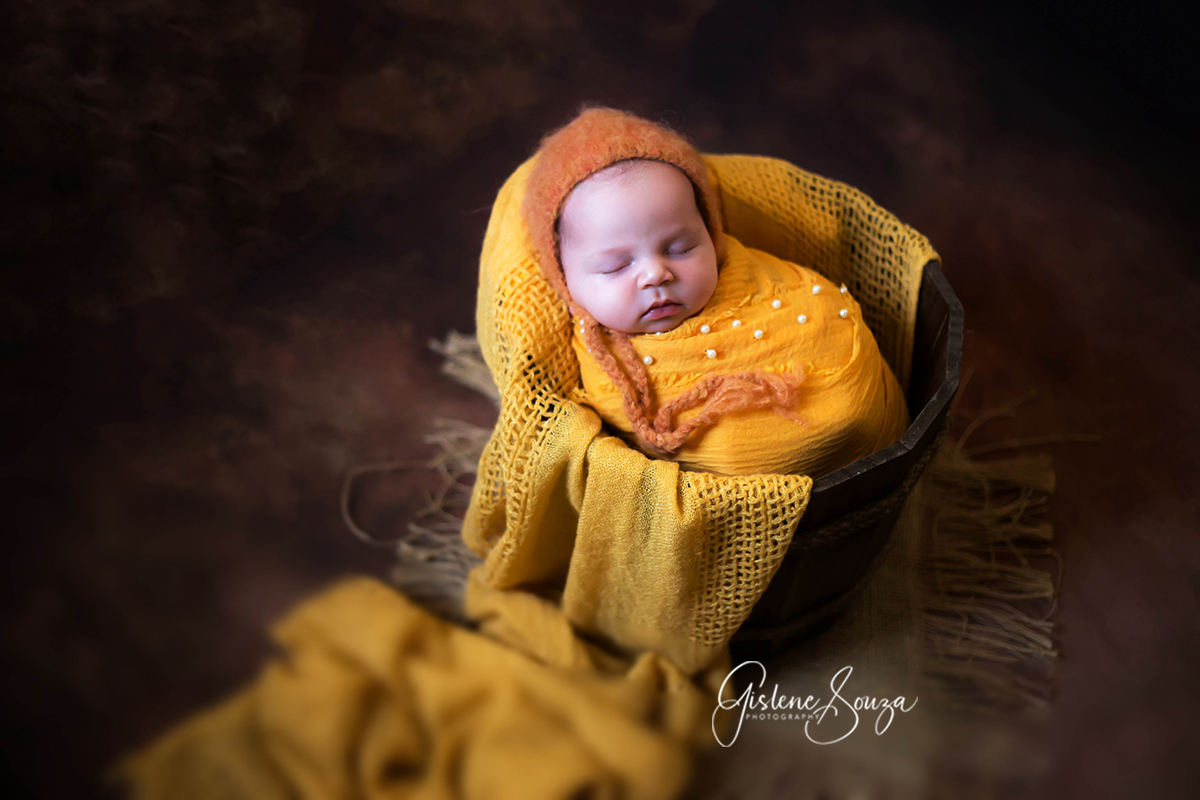 Fotografia deo newborn da Ana Clara 13 dias em Para de Minas. Pose no prop baldinho. Composição em amarelo.