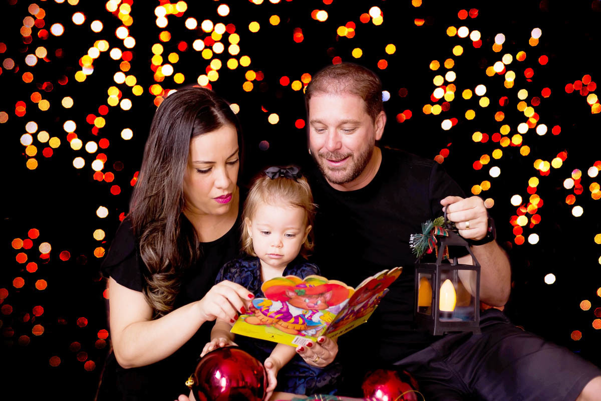 Ensaio de Natal 2020 em Pará de Minas. Ensaio da Cecília. Foto de natal com os pais no cenário de luzes.