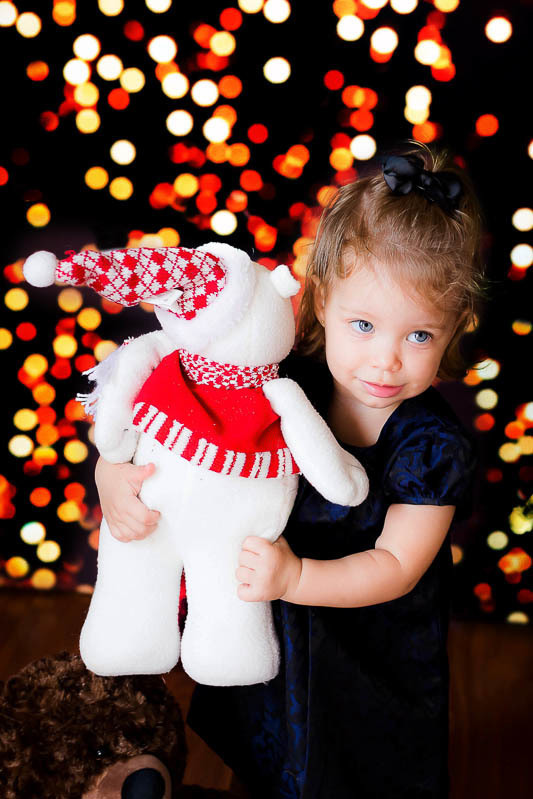 Ensaio de Natal em Pará de Minas no cenário luzes da Cecília. Foto de natal 2020 da Cecília de um aninho e 10 meses com boneco de neve.