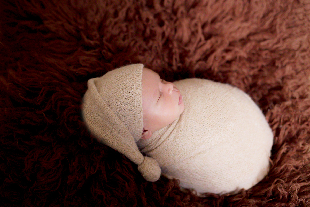 Fotografia de newborn do Davi de 11 dias. Ensaio realizado em Para de Minas. Pose no flokati marrom.