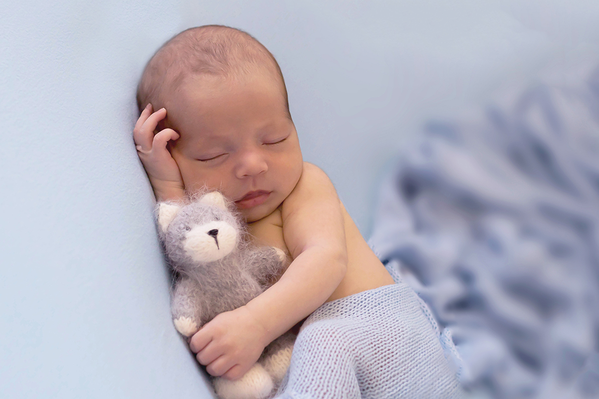 Ensaio de newborn em Para de Minas do João Miguel de 17 dias. Bebê de ladinho no puff.