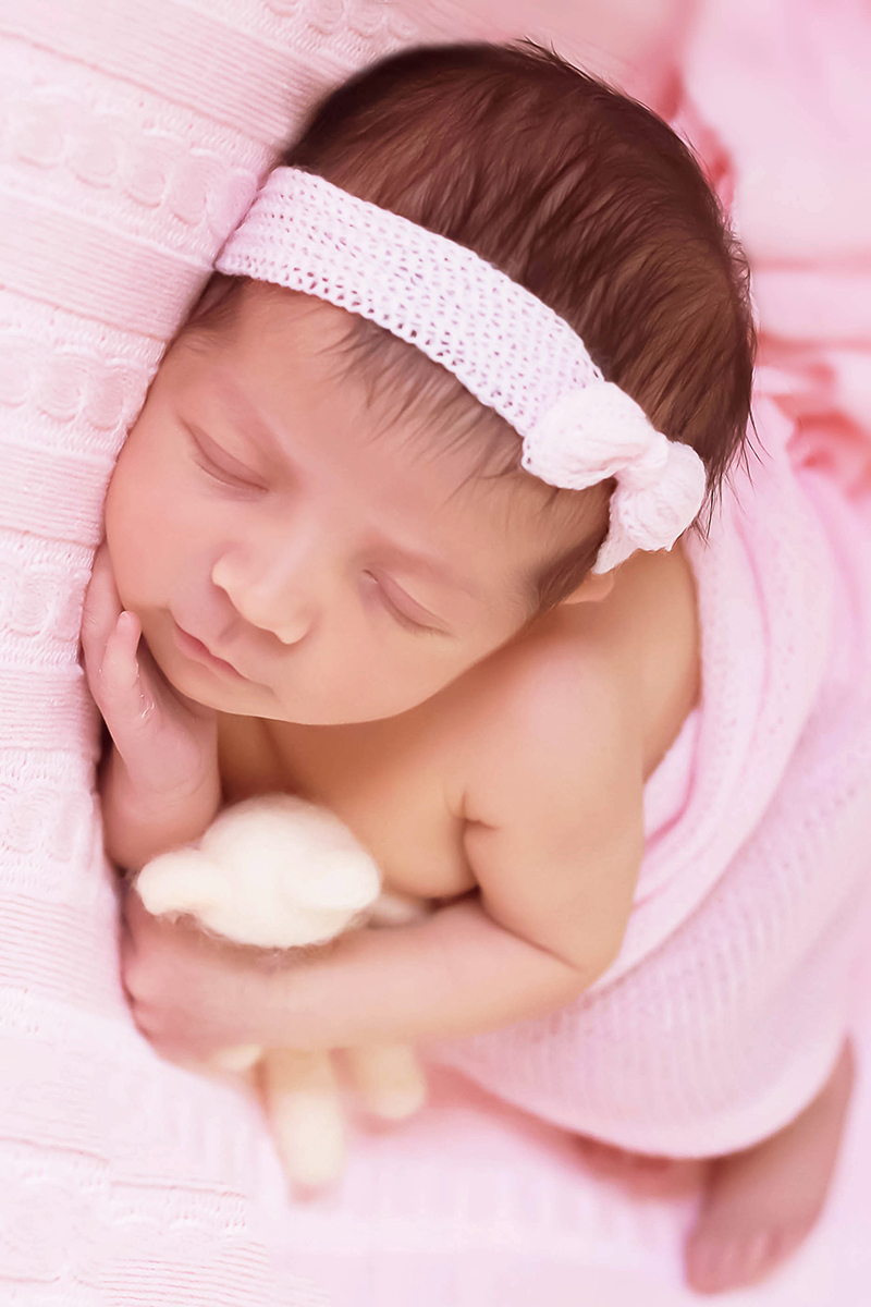 Ensaio de newborn em Pará de Minas da Eloah. Pose bebê de ladinho no puff.