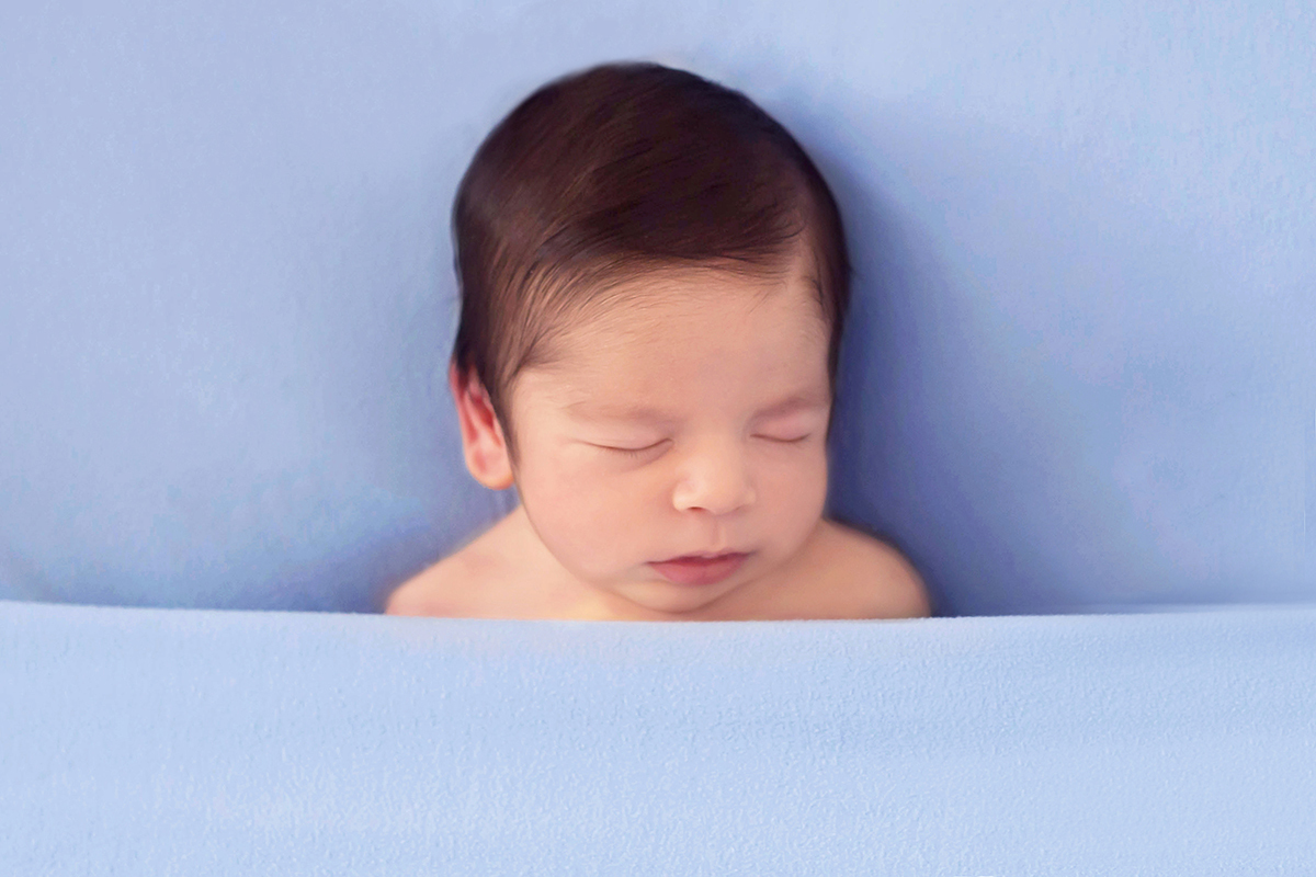 Fotografia de recém nascido do Bernardo em Para de Minas. Pose no puff com a barriguinha para cima