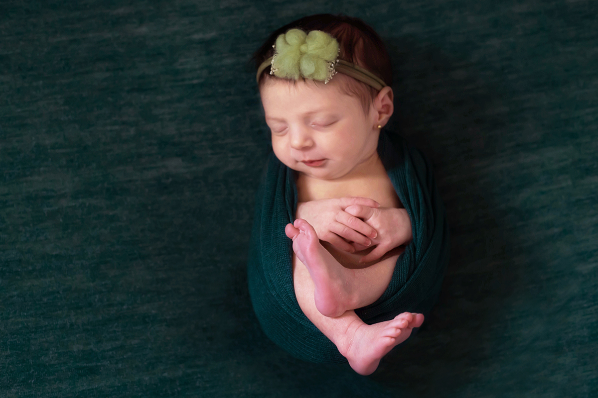 Fotografia de recém nascido da Maria Luísa em Pará de Minas. Pose no puff de barriguinha para cima.