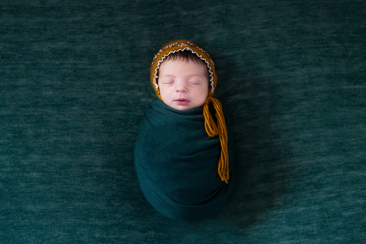 Fotografia newborn pose no puff de barriguinha para cima da Maria Luísa em Para de Minas