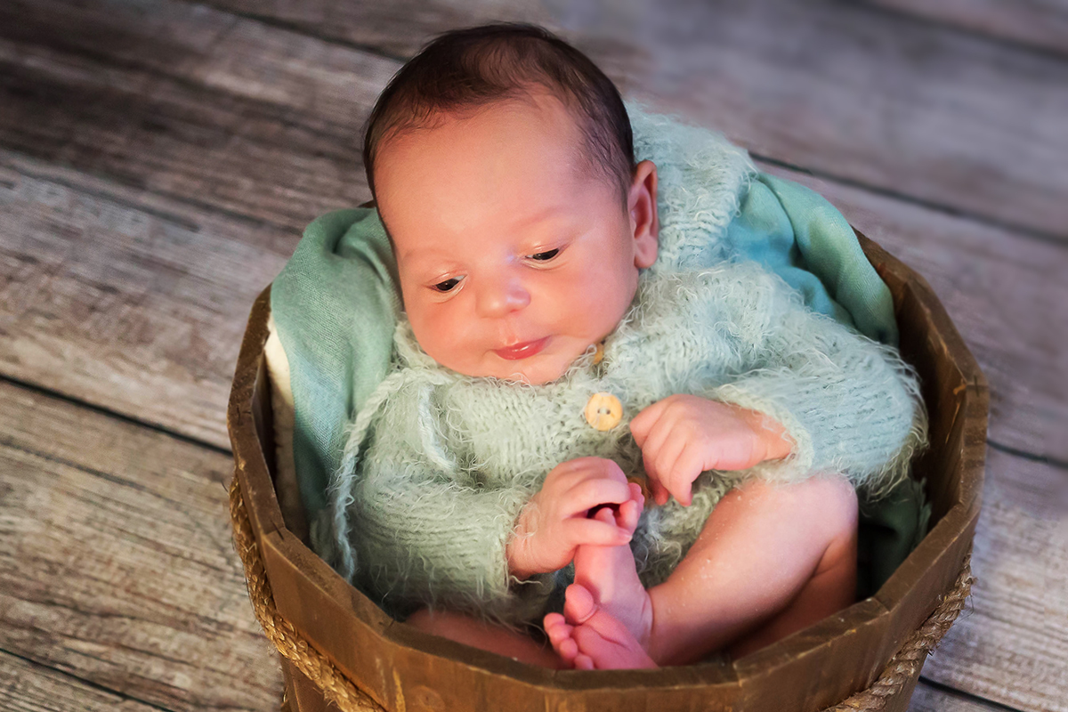Fotografia de Newborn em Para de Minas, do Gabriel de apenas 12 dias. Pose no baldinho de madeira