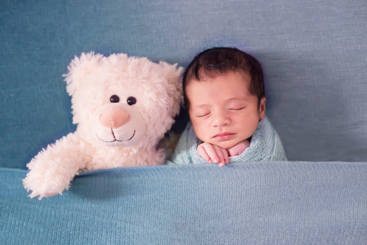 Fotografia de recém nascido do bebê José Minas, de apenas 9 dias, em Pará de Minas. Pose no puff de barriguinha para cima,