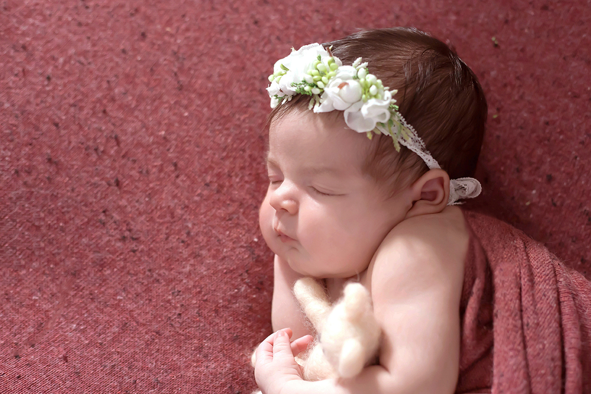 Fotografia de Newborn, da Cecília, pose no puff, em Pará de Minas