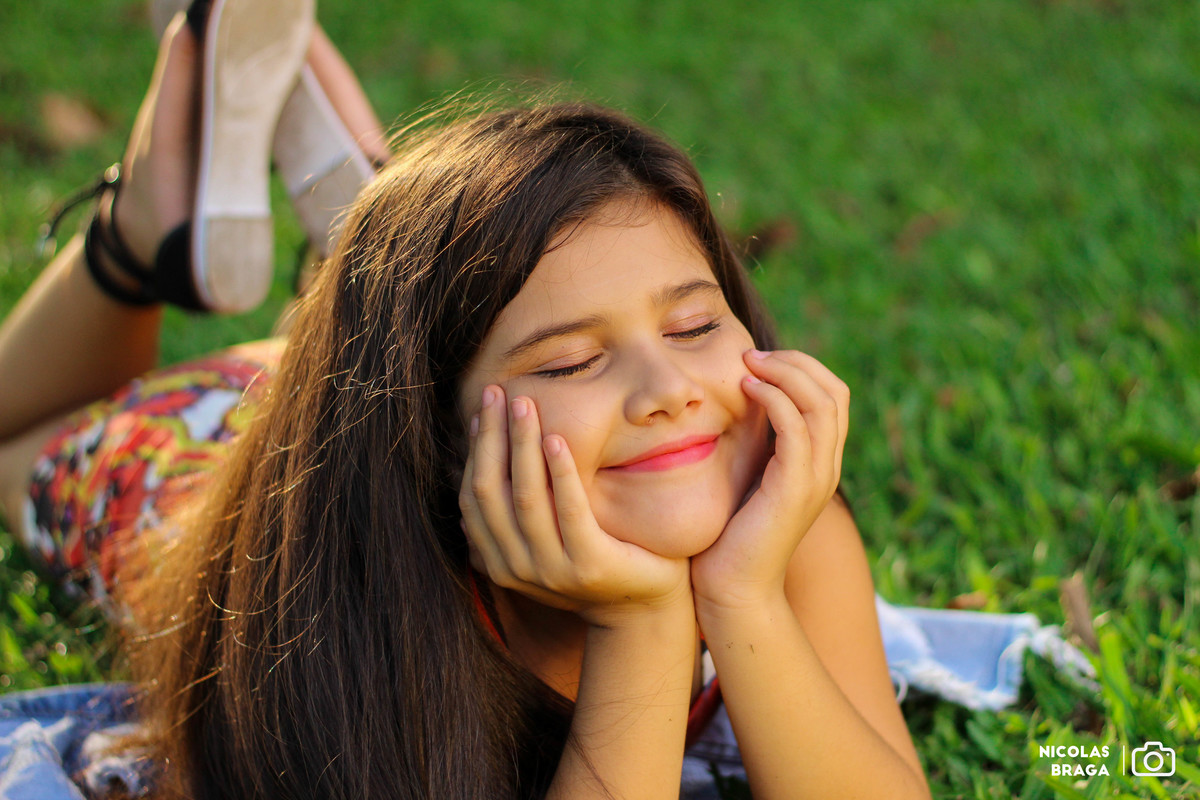 Menina meiga e sonhadora no pôr do Sol