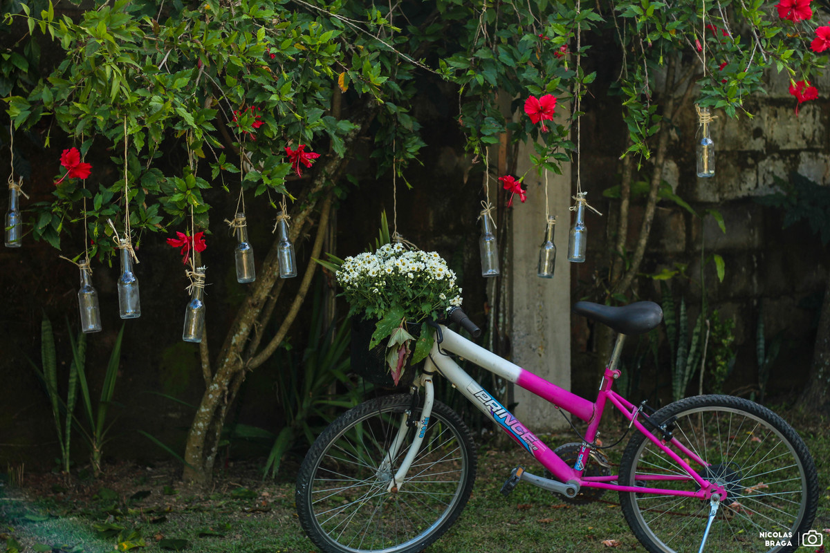 Decoração usando bicicleta, flores e garrafas.