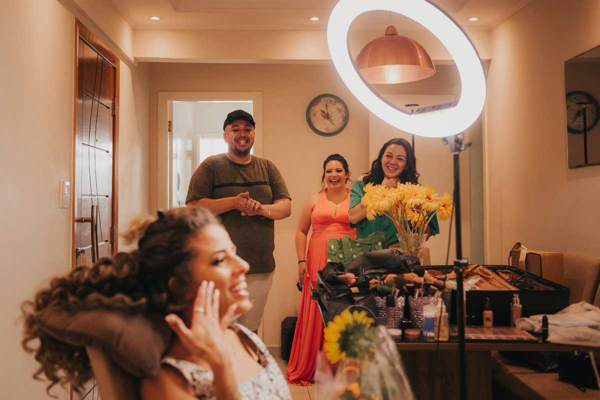 noiva e companheiros emocionados ao ver o recado do noivo para ela, casamento na praia de são vicente, santos e guarujá