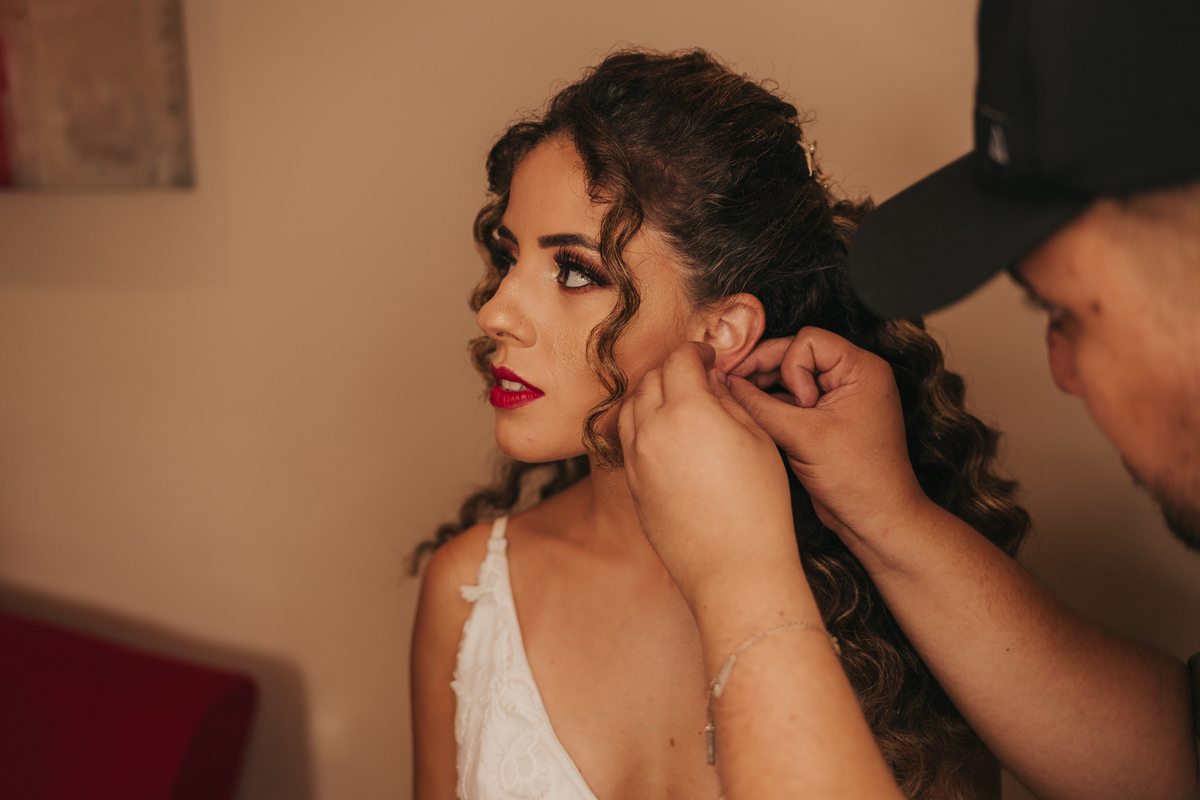 noiva colocando seu brinco em casamento na praia de são vicente, praia grande, santos dia da noiva