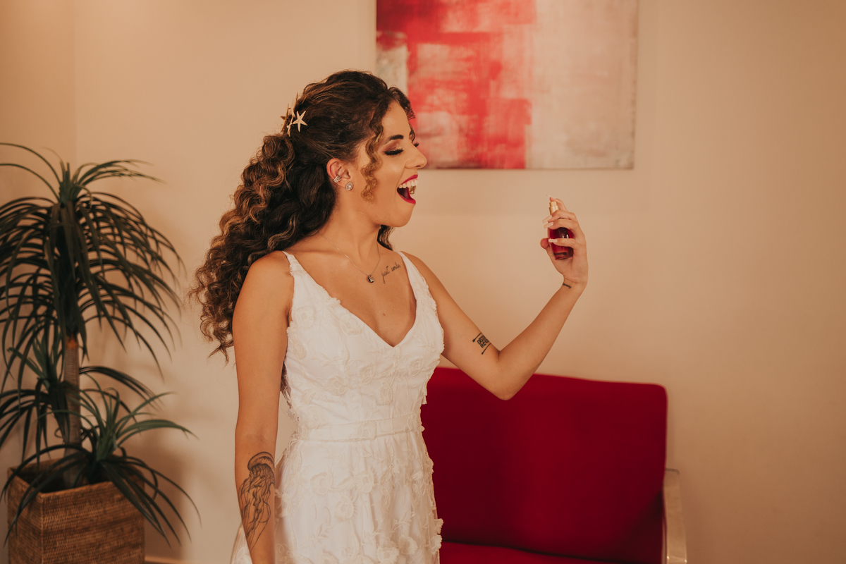 noiva feliz espirrando seu perfume, fia da noiva, making of da noiva, casamento na praia 