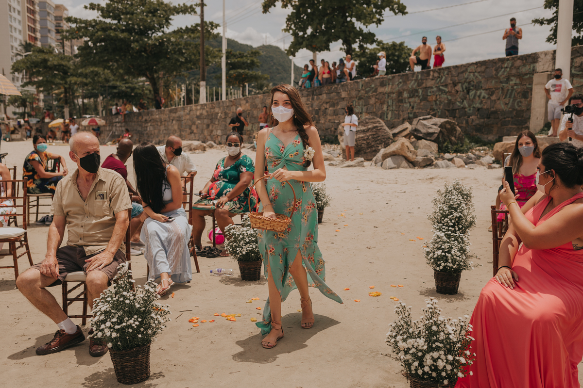 entrada da florista em casamento pé na areia na praia de são vicente
