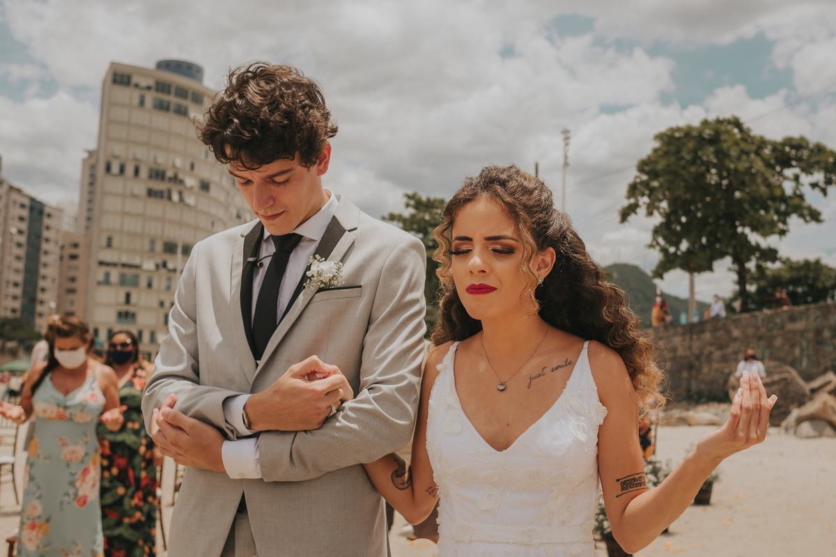 oração dos noivos em celebração de casamento na praia de são vicente. 