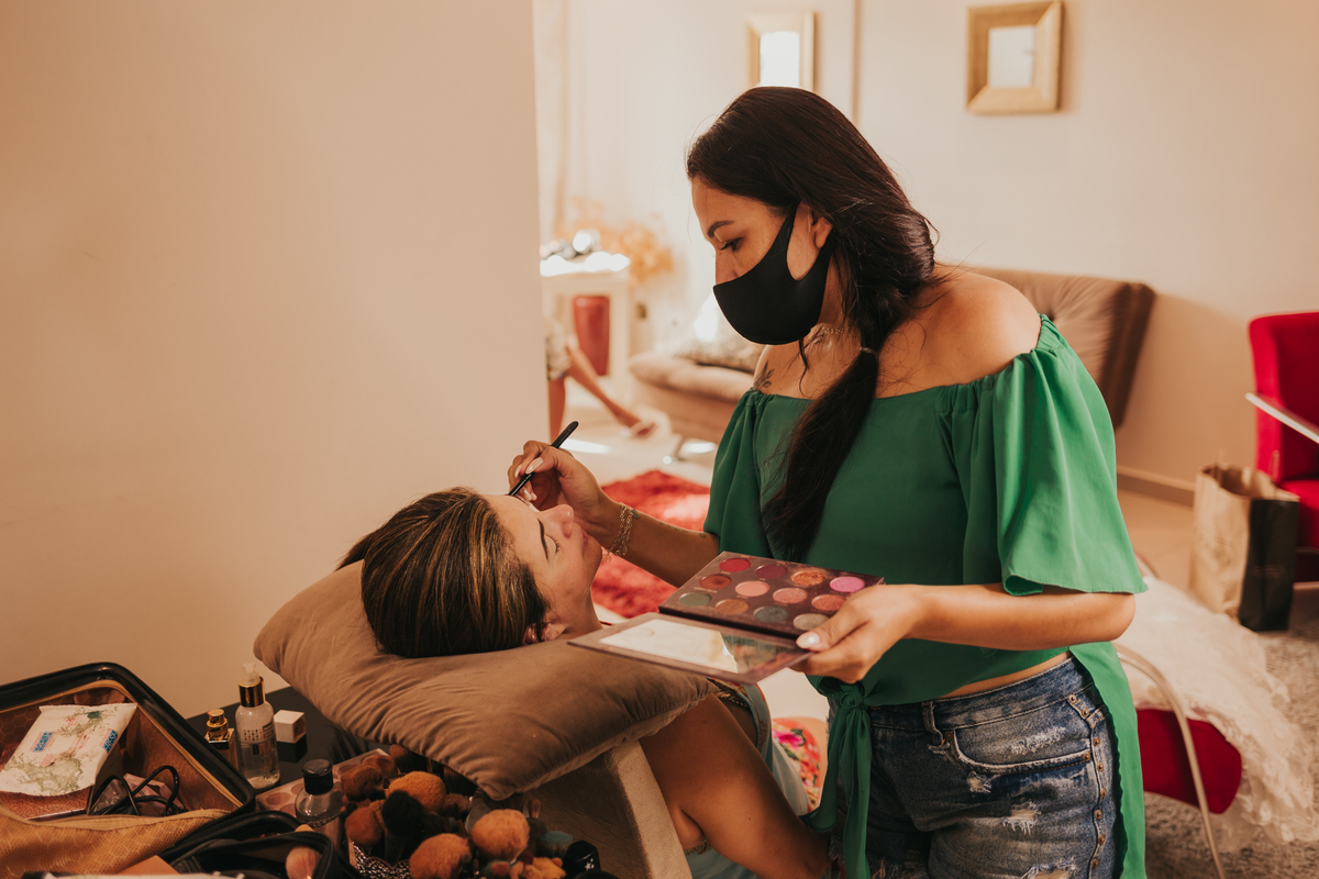 Mãe da noiva se maquiando no making of da noiva