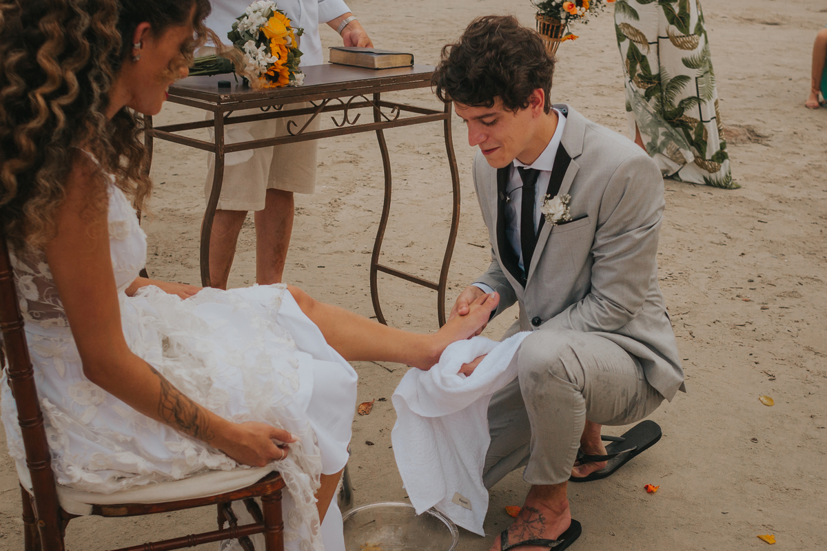 momento dos lava-pés em cerimonia de casamento de dia na praia