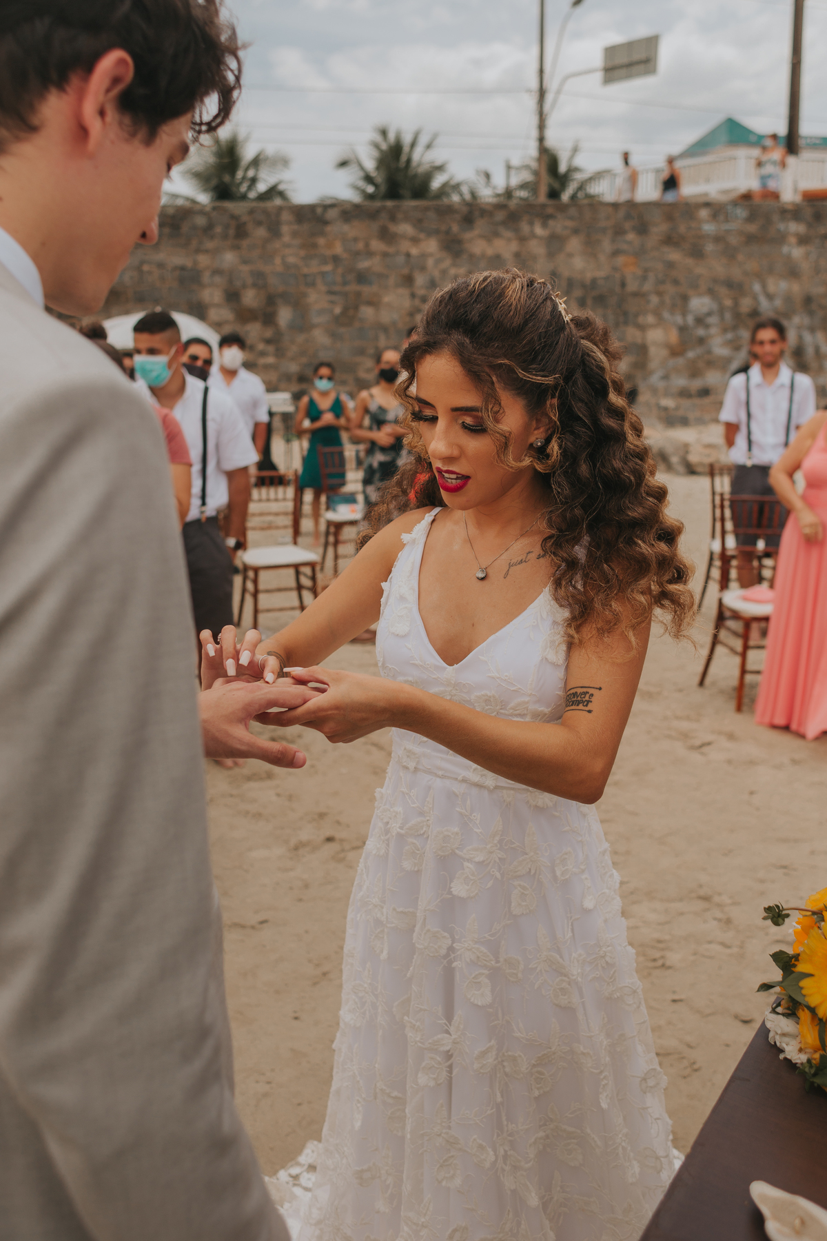 noiva colocando a aliança no noivo em cerimonia de dia na praia de são vicente