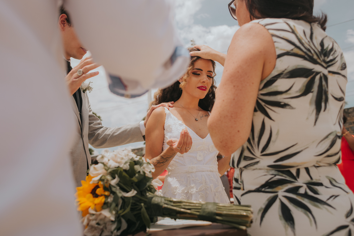 oração com imposição de mão na noiva em casamento de dia na praia
