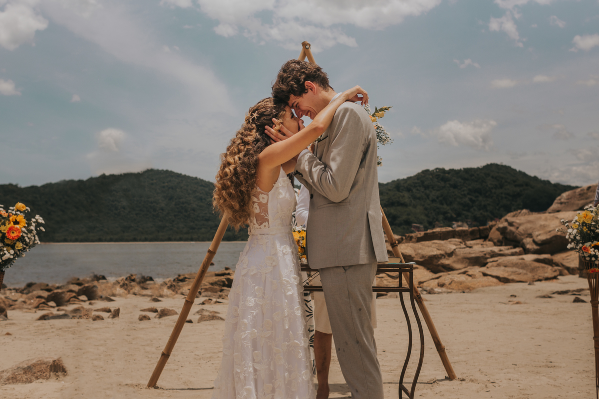 carinho entre os noivos no final da cerimonia em casamento na praia