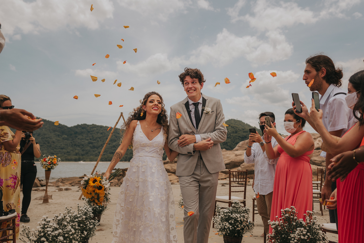 saida dos noivos com petalas de rosas sendo jogada pelos padrinhos