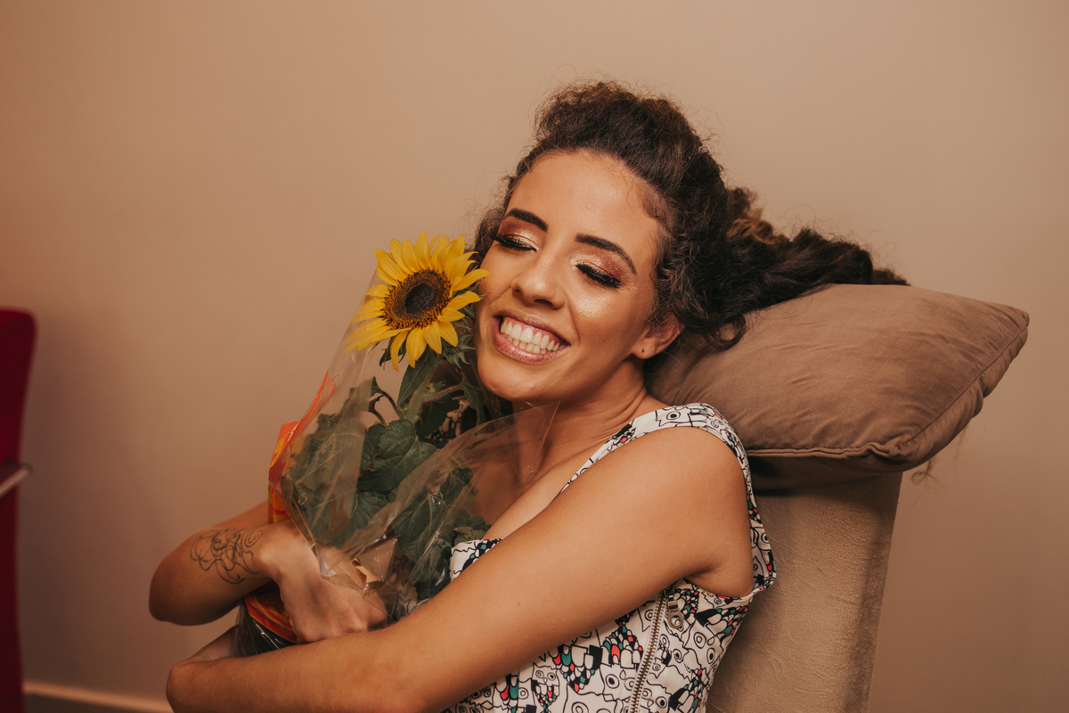 noiva abraçando o girassol que ganhou de presente do noivo, reações espontâneas para casamento