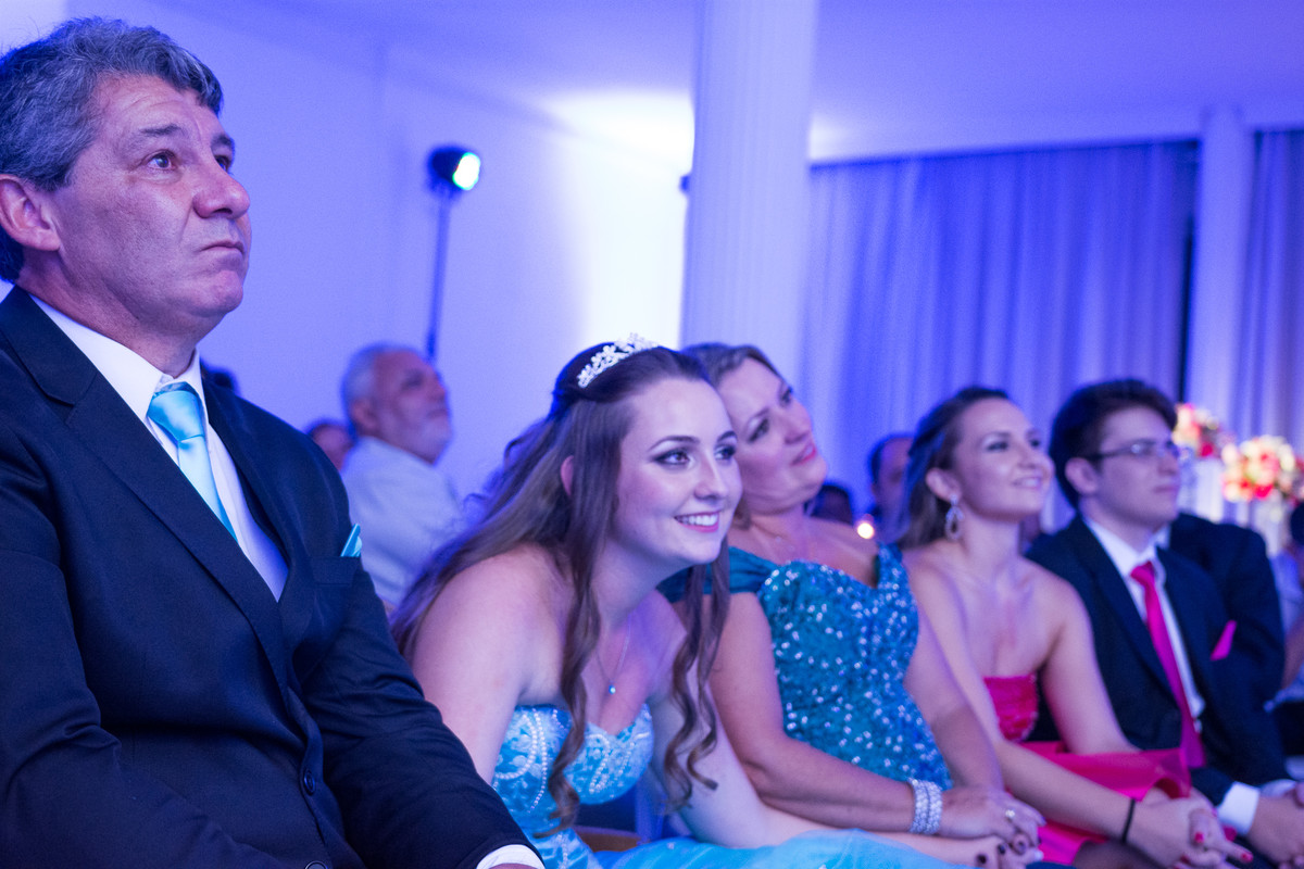 familia emocionada ao ver a retrospectiva em festa de 15 anos