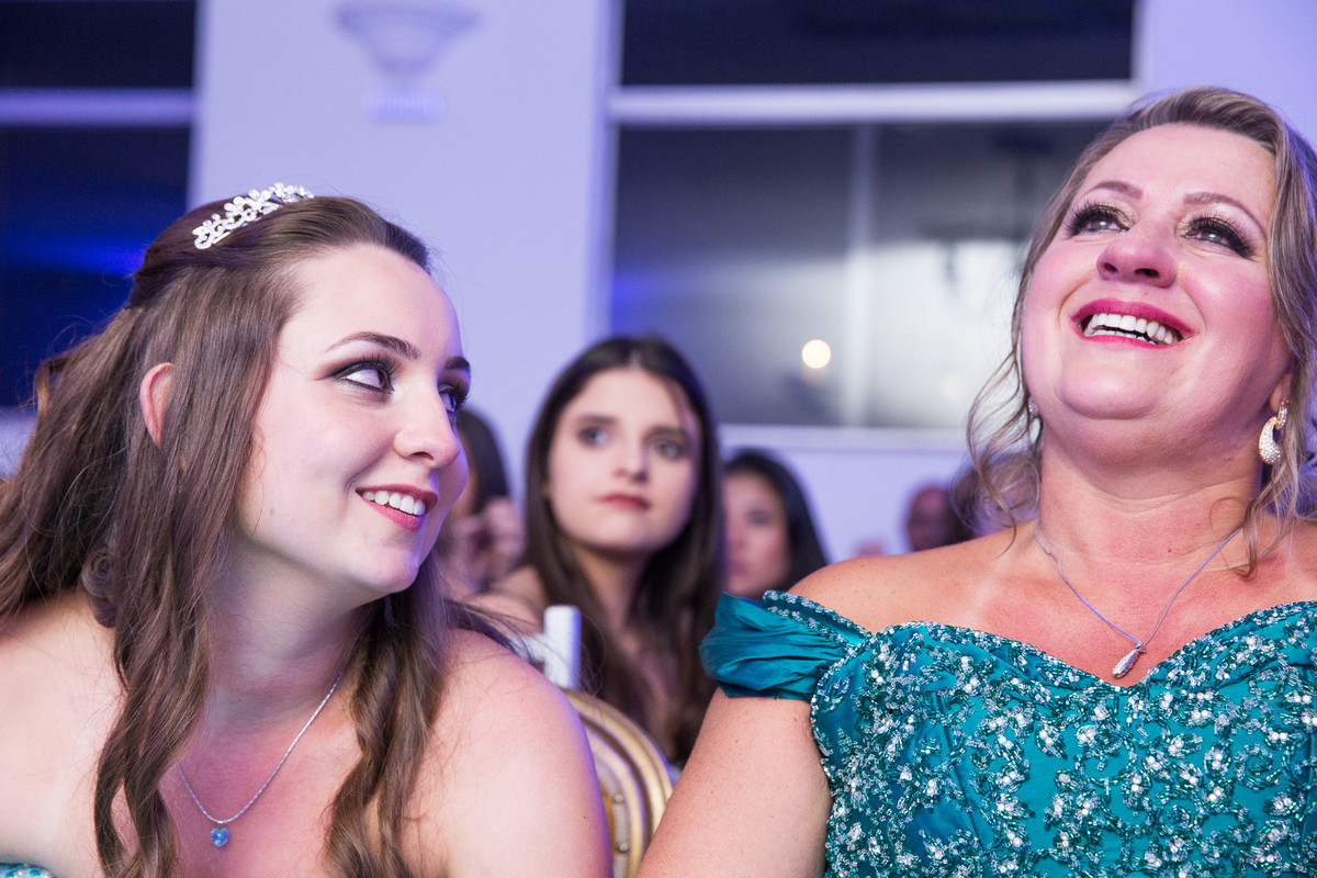 familia emocionada ao ver a retrospectiva em festa de 15 anos