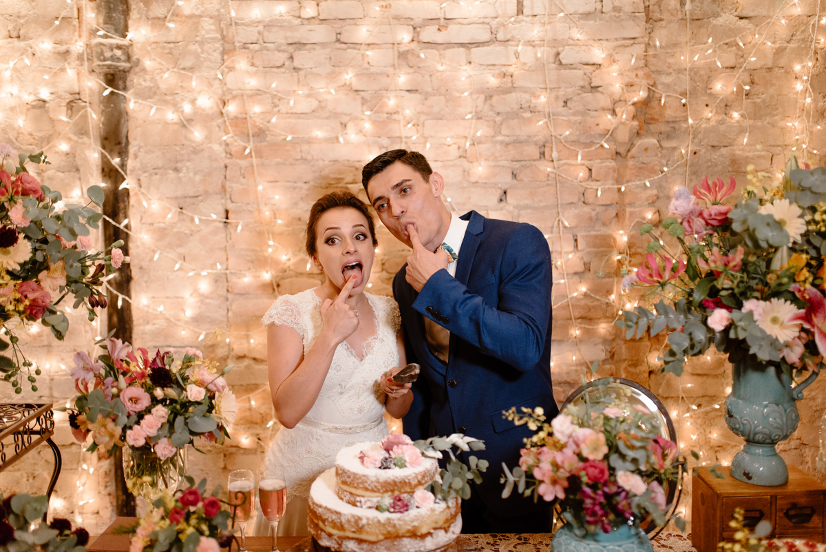 noiva e noivo em furando o bolo com o delo e experimentando no click do fotógrafo de casamento SP Thiago Farias na Casa Quintal numa cena irreverente