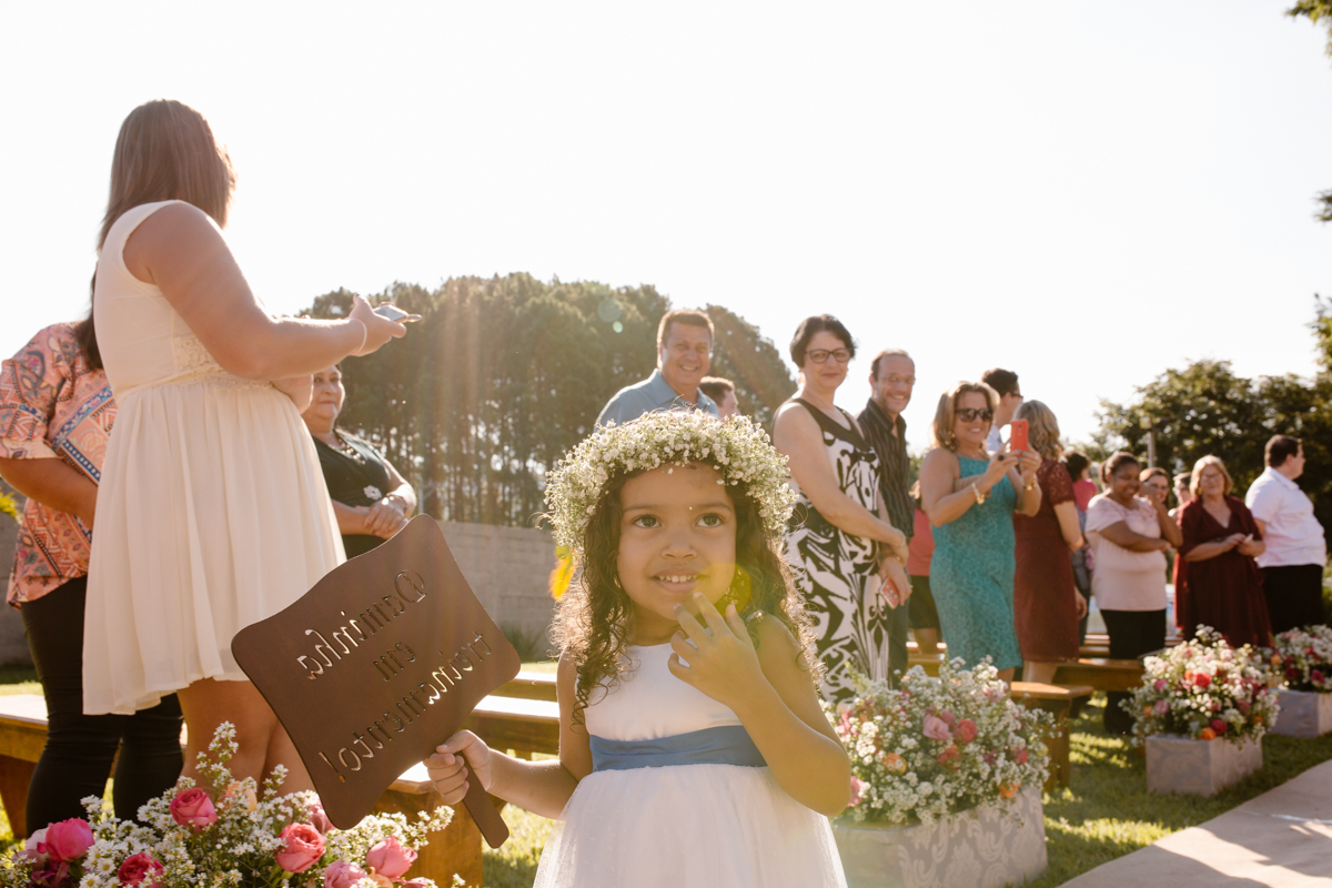 Daminha entra com coroa de flores na cabeça e rouba a cena