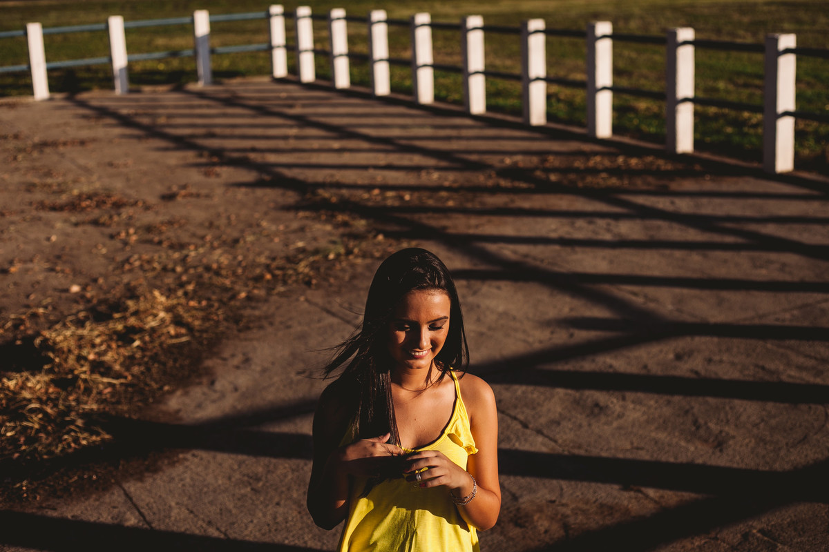 menina na frente da sombra de cerca
