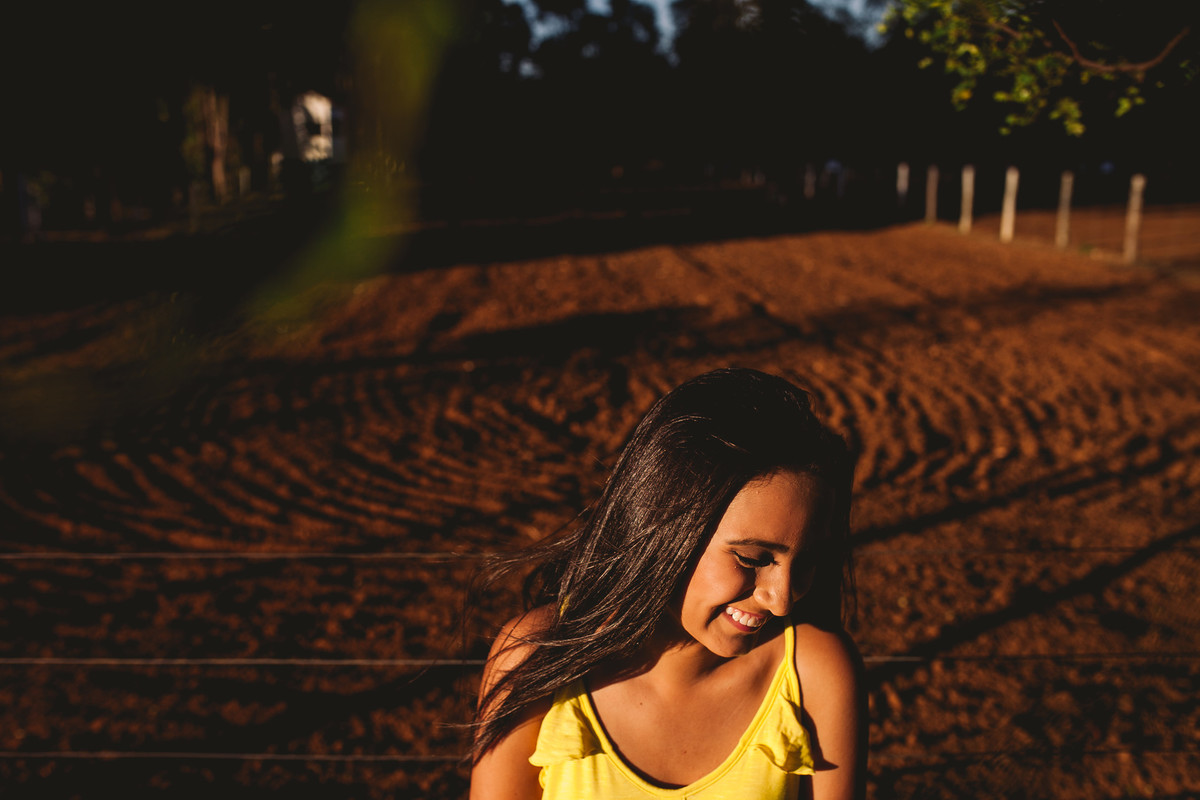 gabi sorrindo de lado com fundo de terra