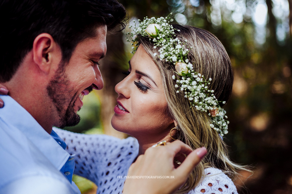 casal sorri em floresta