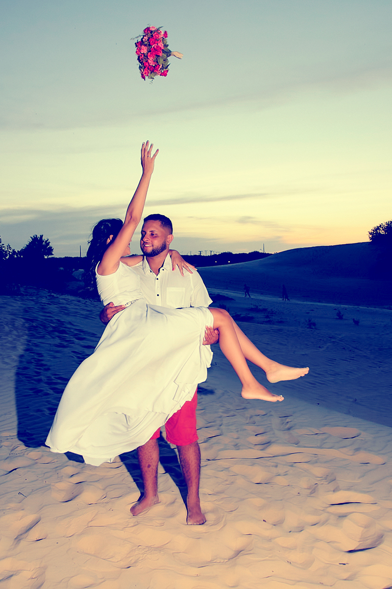 casamento ao livre , nas dunas, noiva jogando o buque.