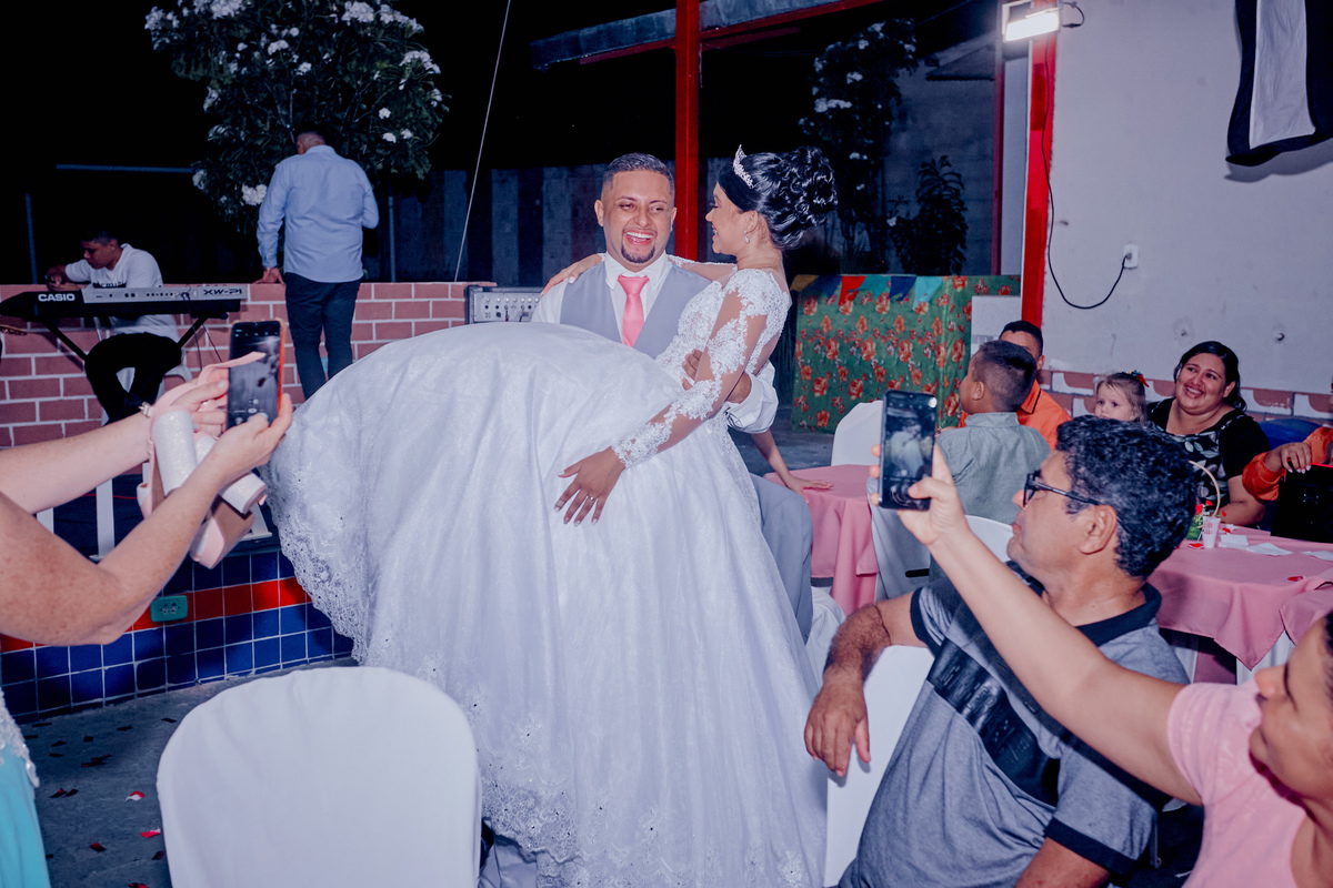 recém-casada é carregada nos braço pelo esposo