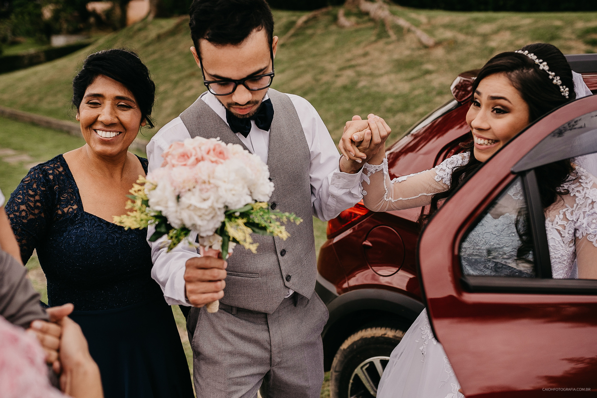 Fotografia de casamento entrada do noivo noivo sorrindo casar no campo casamento de dia noivo com os pais casamento ao ar livre fotografia documental por caio henrique sao paulo fotografo de casamento entrada da noiva