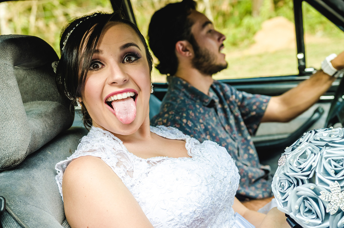 Fotografia de noiva chegando na cerimônia em carro antigo