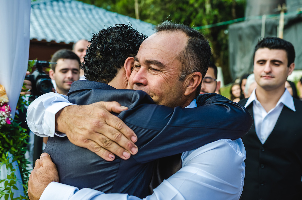 Foto do pai da noiva abraçando o noivo em casamento em Nazaré Paulista