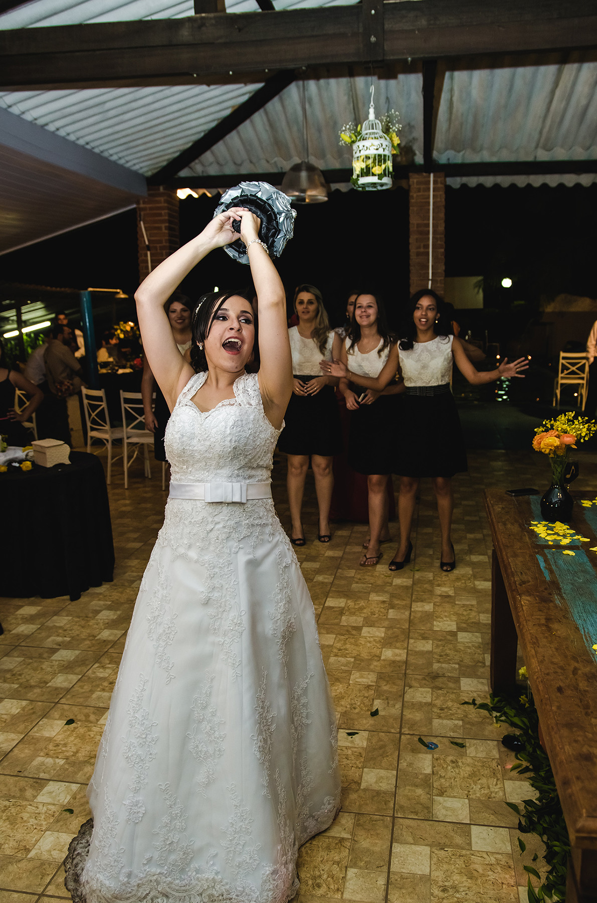Foto criativa de noiva jogando o bouquet em casamento de dia em Nazaré Paulista
