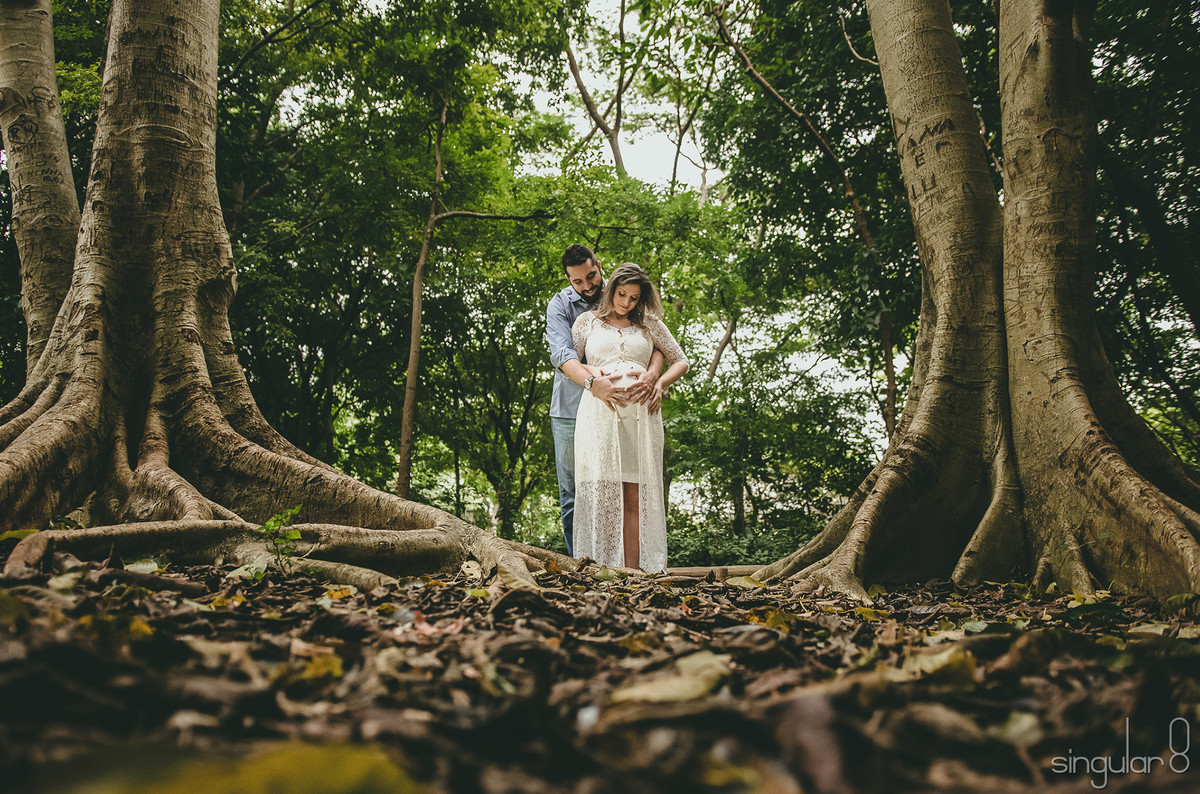 casal entre árvores em ensaio gestante