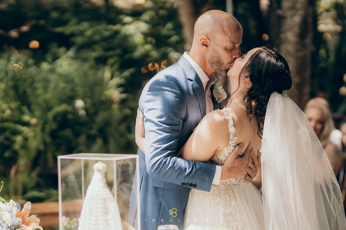 Primeiro beijo dos noivos no casamento ao ar livre em Mairiporã.