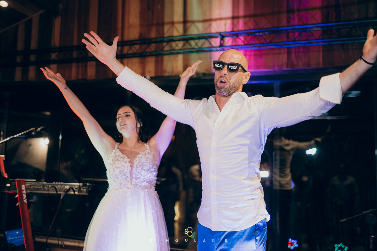 Noivos comemorando com muita alegria na festa de casamento.