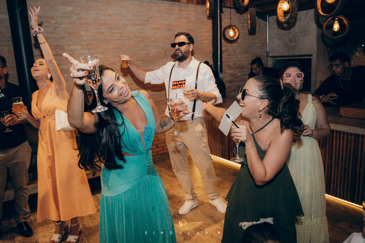 Casal curtindo a festa de casamento ao lado dos convidados.