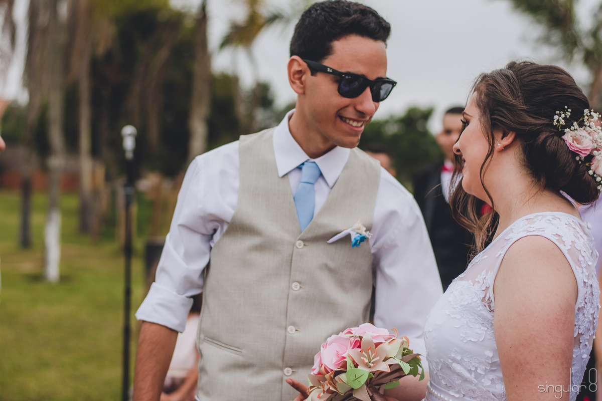 olhar-apaixonado-do-noivo-para-a-noiva-na-cerimonia-casamento-de-dia-noivo-de-óculos-escuros